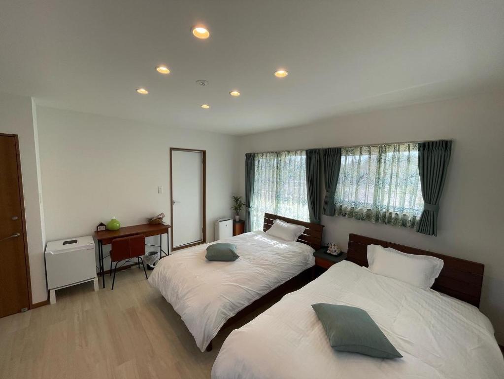 座间味村Dining & Stay 38 Miyahira的一间卧室配有两张床、一张桌子和一面镜子