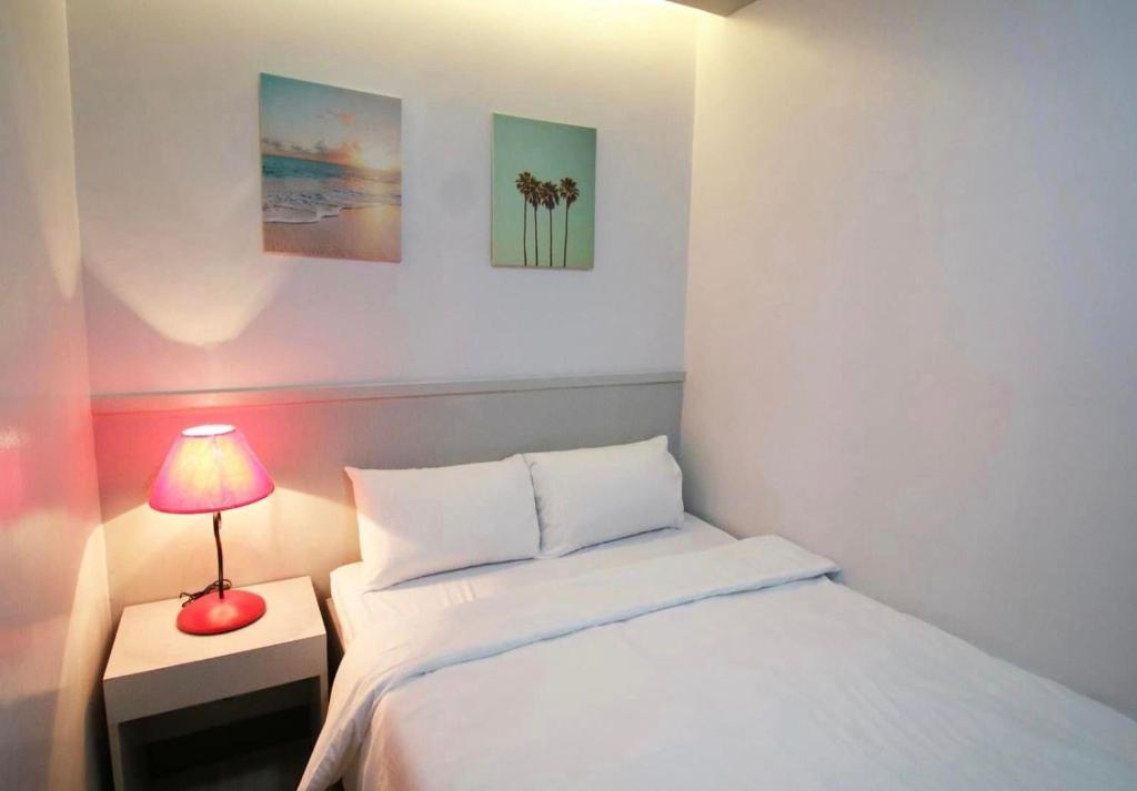 纳苏格布SANDS Hotel Nasugbu的一间小卧室,配有一张床和一盏红灯