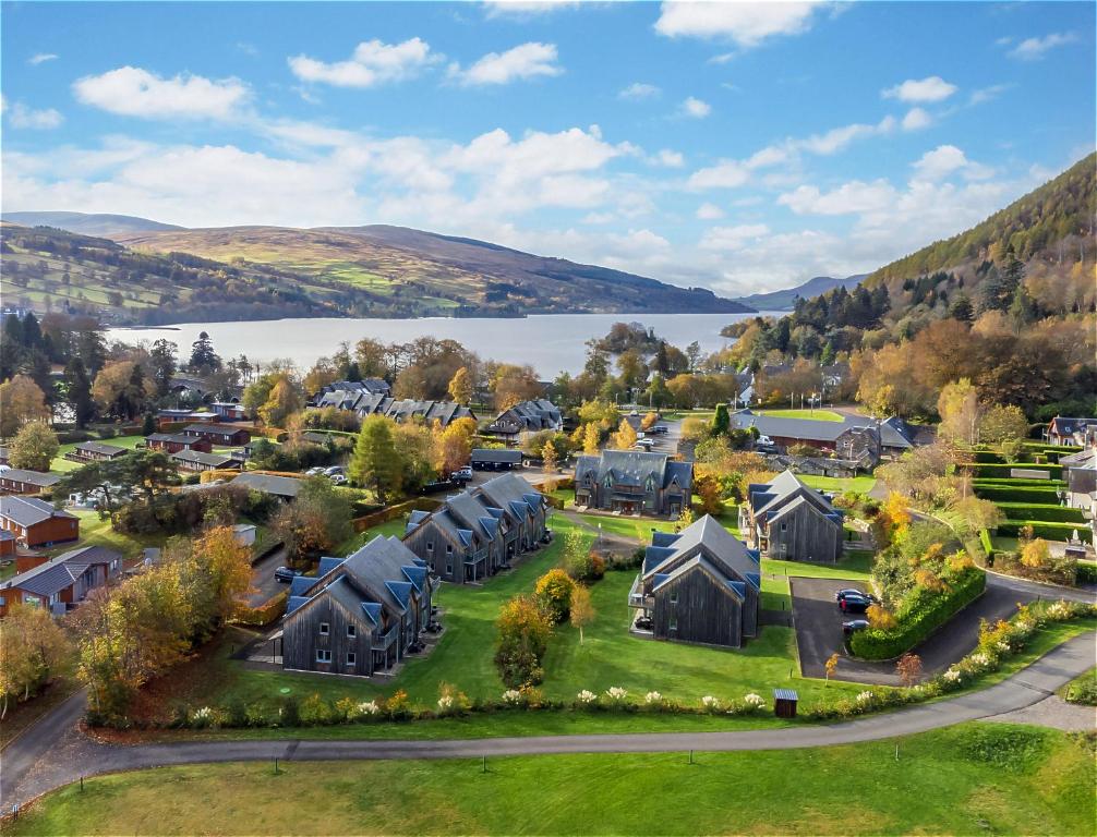 肯莫尔Mains of Taymouth Country Estate 5* Maxwell Villas的享有村庄的空中景致,设有房屋和湖泊