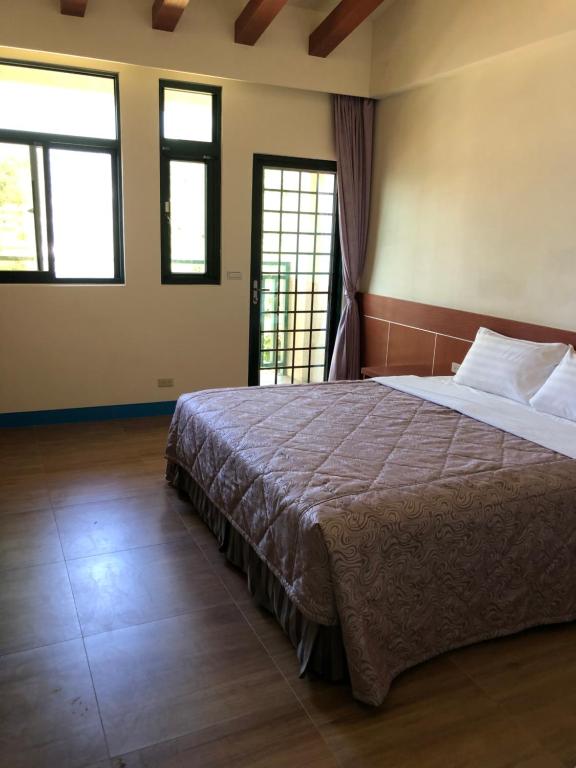 北竿乐活海景民宿的一间卧室设有一张大床和两个窗户。