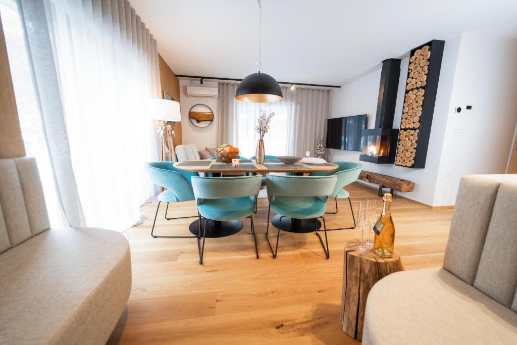 克拉尼斯卡戈拉Bor in Bor Luxury Apartment with sauna & garden - Kranjska Gora的一间带桌子和蓝色椅子的用餐室