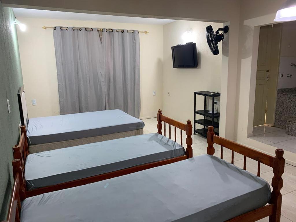 因比图巴Apartamento itapirubá的一间配有电视的客房内的三张双层床