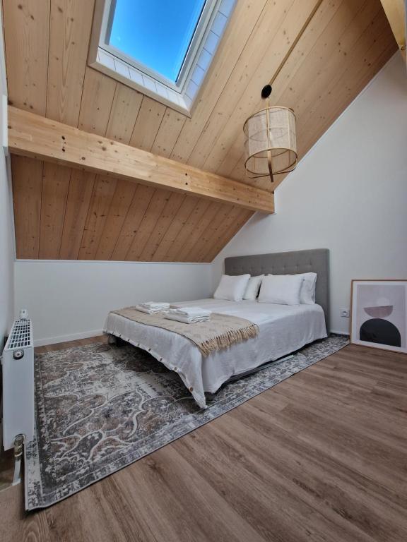 莫尔比耶Duplex type chalet dans le Jura的一间卧室设有一张床和木制天花板