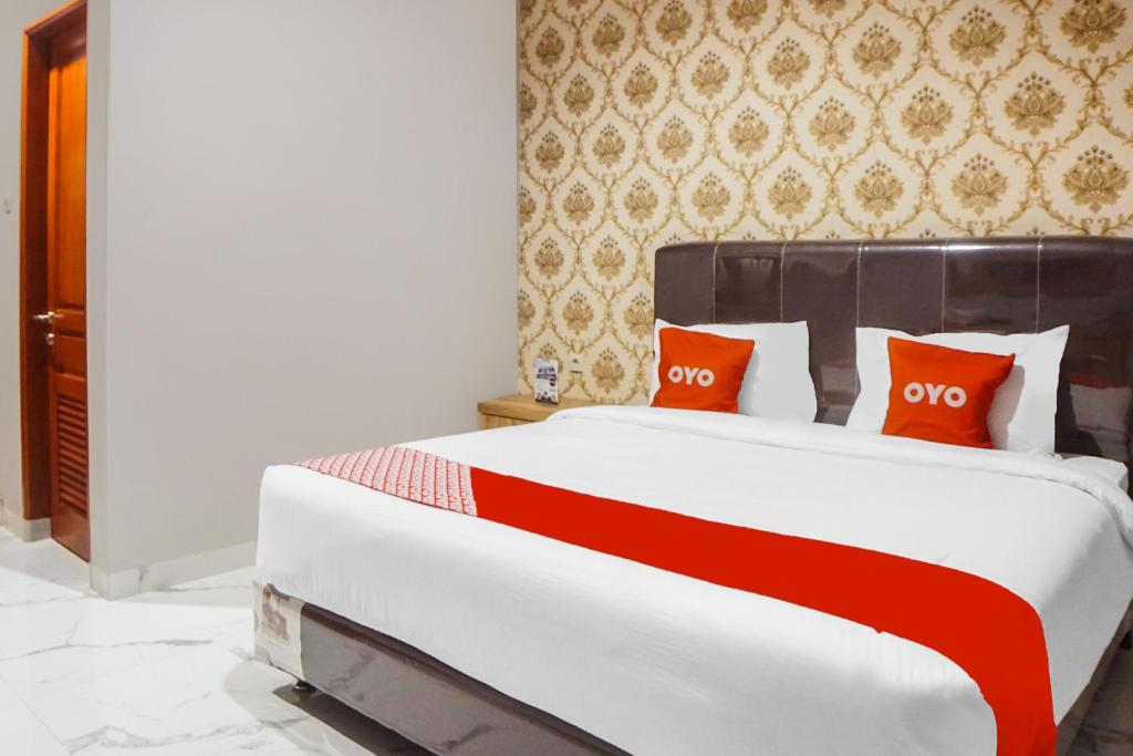 棉兰SUPER OYO Capital O 92066 Papakoel Hotel & Cafe的一张带红色枕头的床