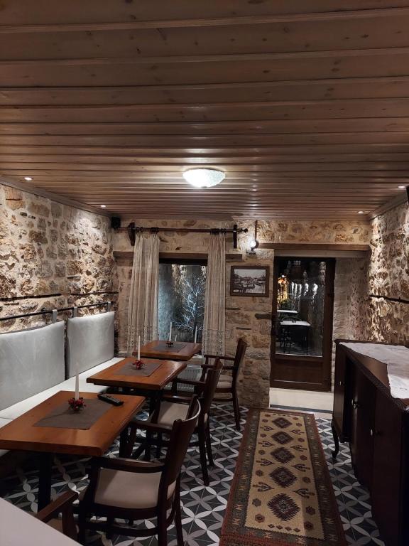 约阿尼纳VIRSA BOUTIQUE ROOMS的一间设有木桌和椅子的餐厅
