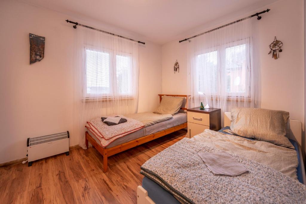 隆代克-兹德鲁伊Domek bez zegara的一间卧室设有两张床和两个窗户。