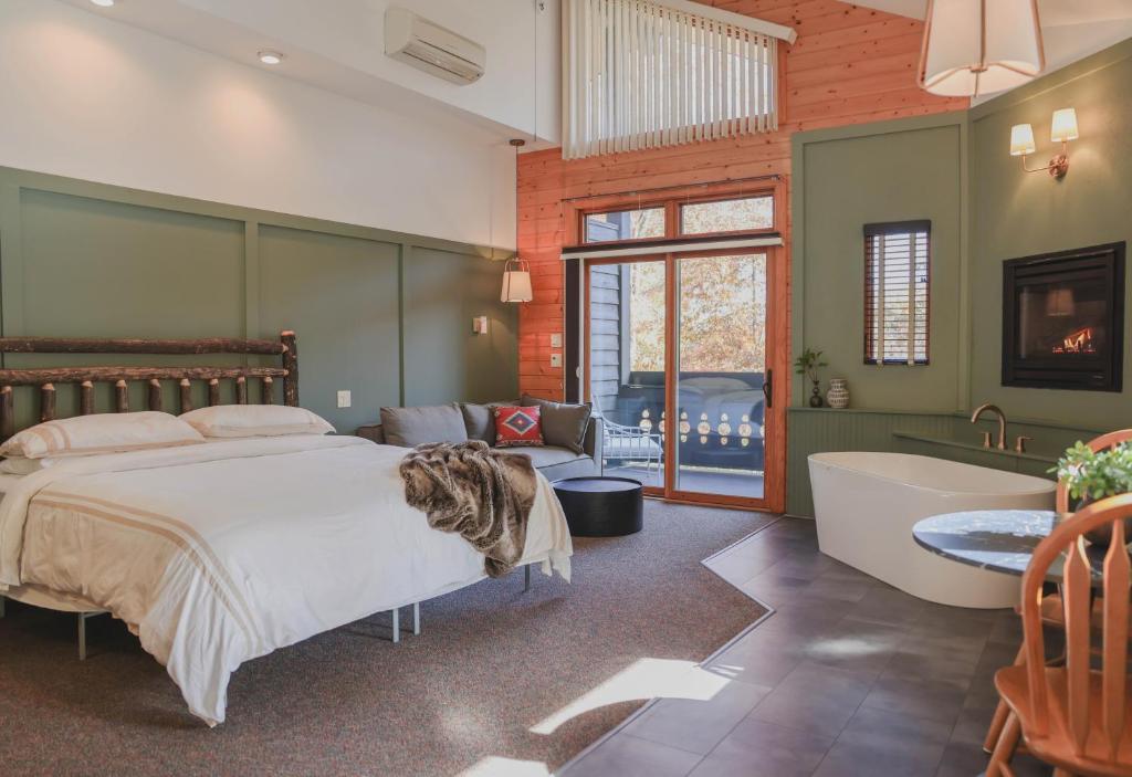 惠提尔Outland Chalet & Suites Great Smoky Mountains的一间卧室配有一张床、一个浴缸和一个浴缸