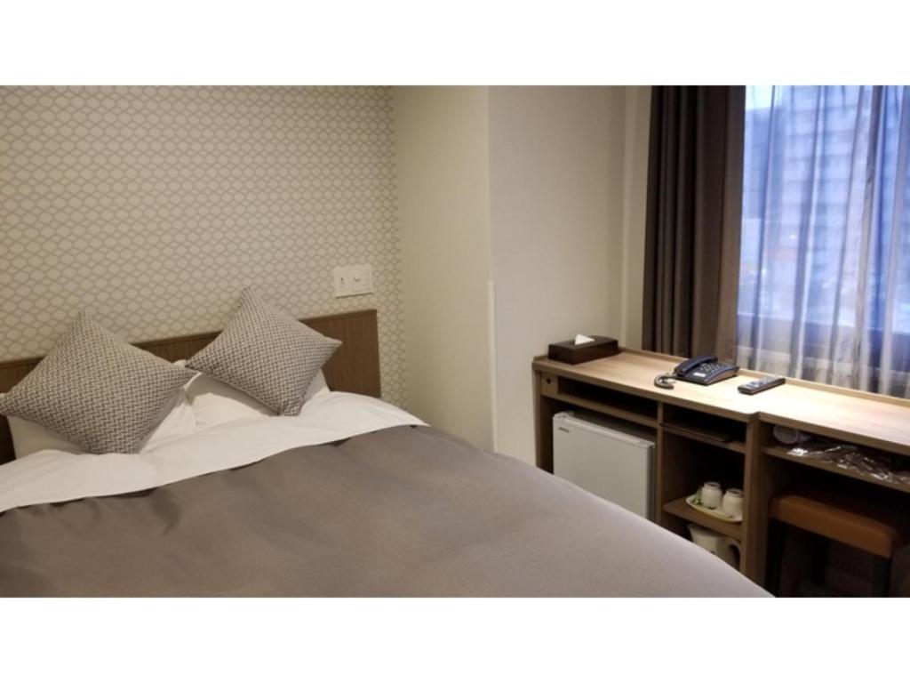 宇都宫Sun Royal Utsunomiya - Vacation STAY 02512v的一间卧室配有一张床、一张书桌和一个窗户。