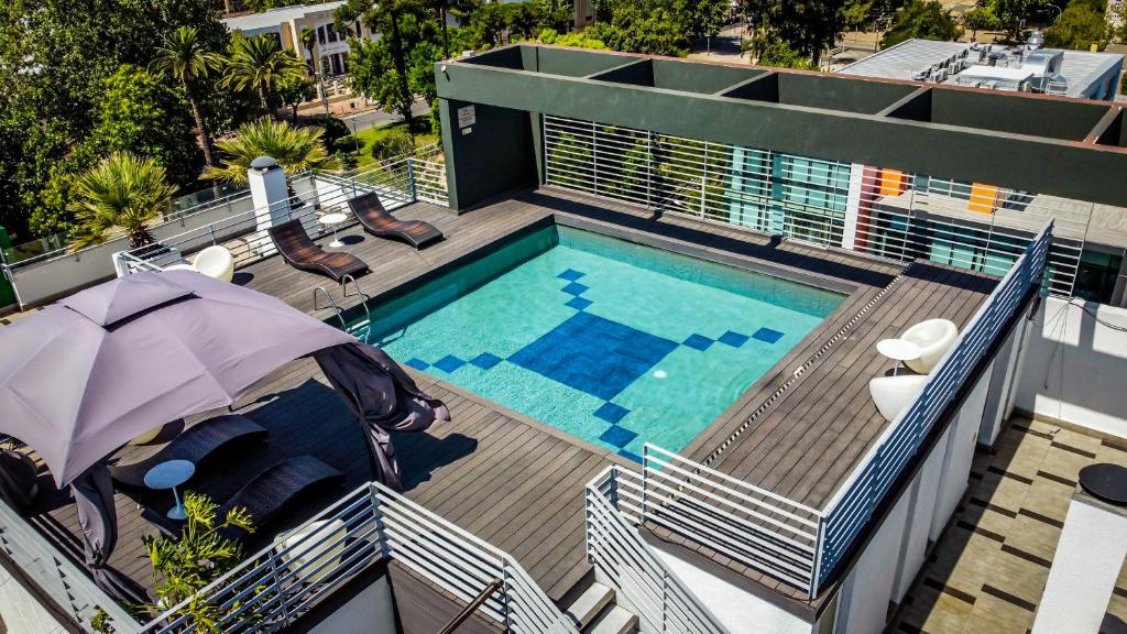 塔尔卡Ecohotel Talca的游泳池顶部景,带遮阳伞