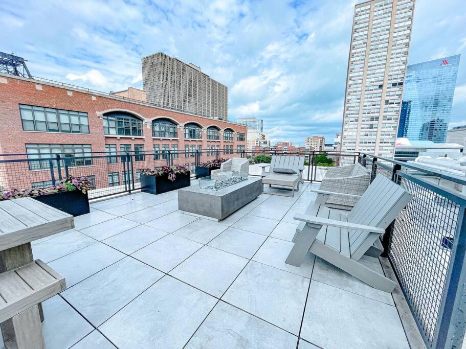 芝加哥Modern 2BR in South Loop Near Soldier Field, Grant Park, Downtown, &amp; Lakefront Trail的建筑物上的带桌椅的阳台