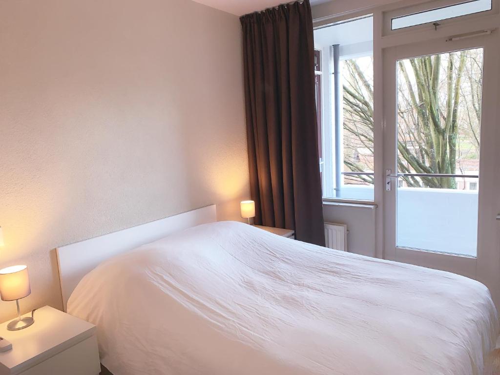 莱顿KeyCity Apt Near Amsterdam & The Hague的卧室配有白色的床和窗户。