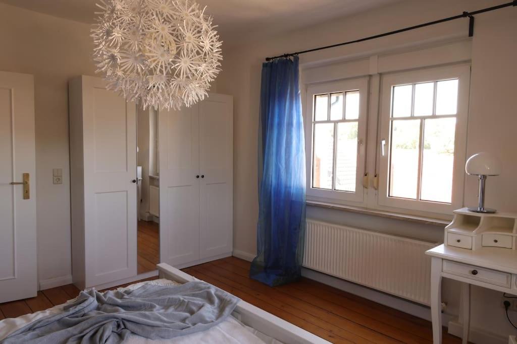 布雷滕Charmante, großzügige Ferienwohnung Villa Fleurie的一间卧室配有一张床和一个吊灯