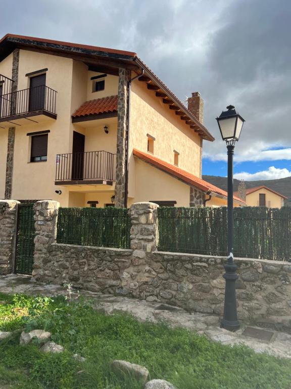 Pinilla del ValleEncanto - Pinilla del Valle的栅栏和房子前面的路灯