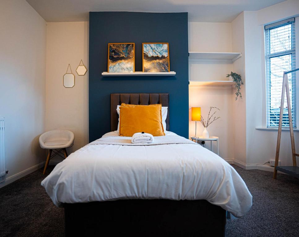 纽尼顿Comfortable equipped House in Nuneaton sleeps5 with FREE parking的一间卧室配有一张蓝色墙壁的床
