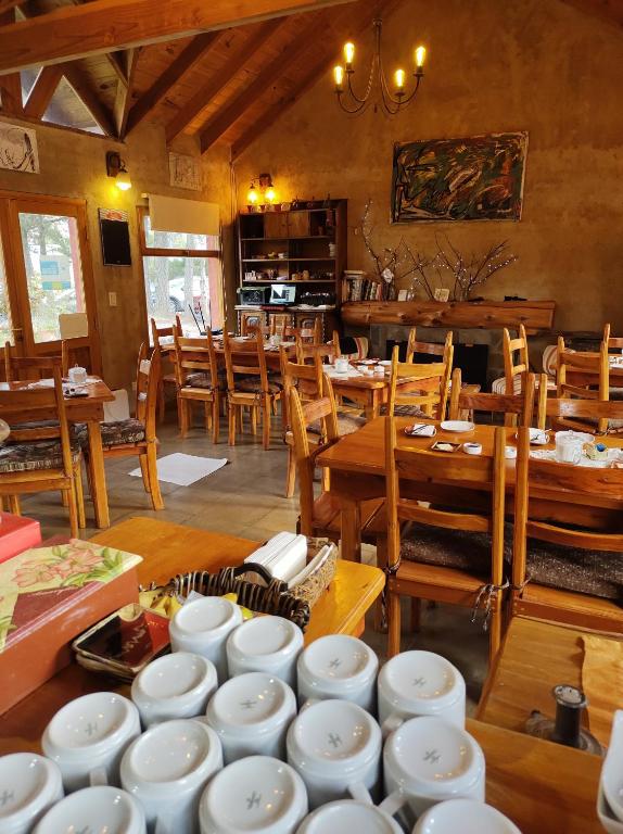 普埃洛湖Valle Puelo的用餐室配有桌椅,供应白色菜肴