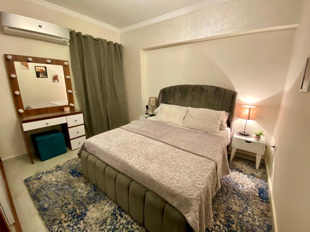 开罗Cozy 2BR Apartment in Maadi的一间卧室配有一张大床和镜子
