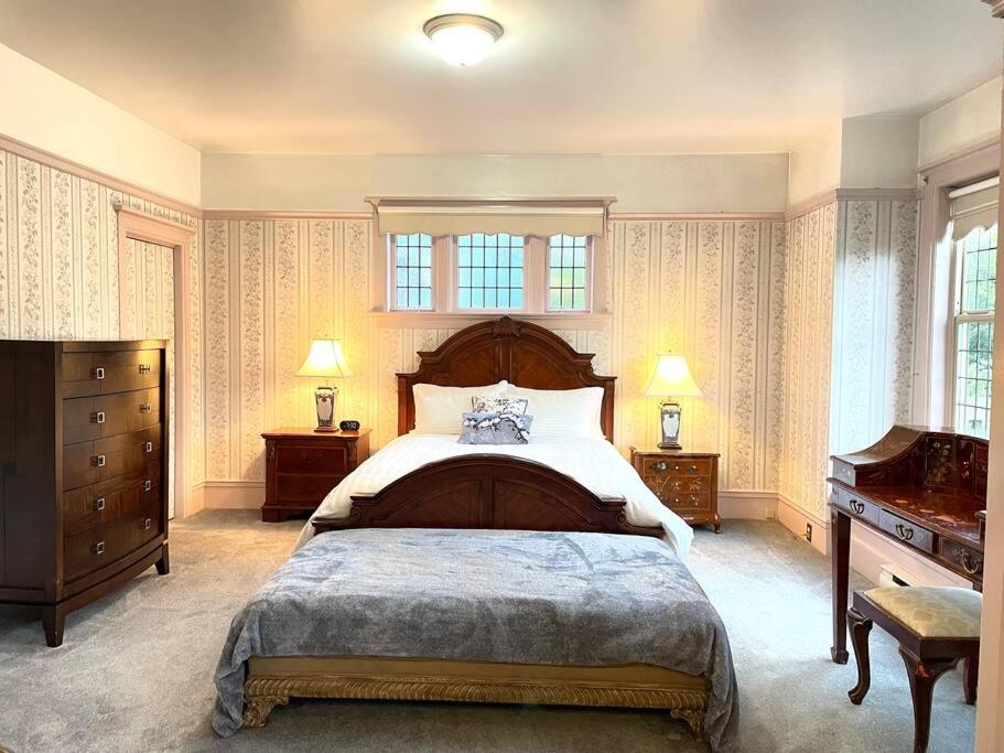 维多利亚Parlor Suite in Heritage Manor, Fairfield, near DT的一间卧室配有一张大床和一架钢琴