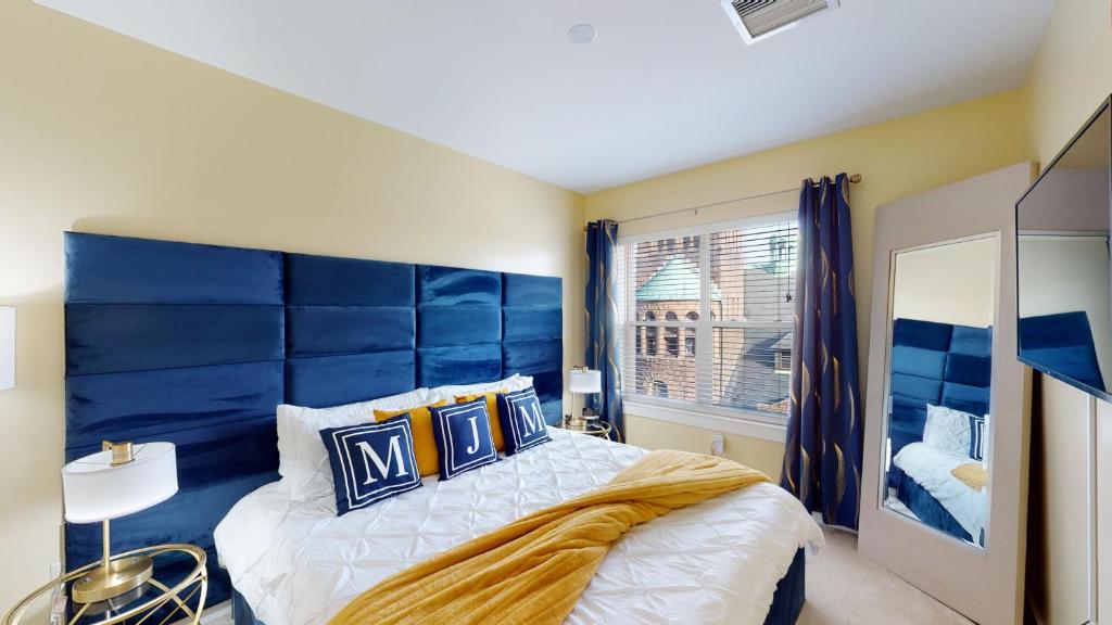 马尔登Corporate King Malden Square # 431的一间卧室配有一张带蓝色床头板的大床