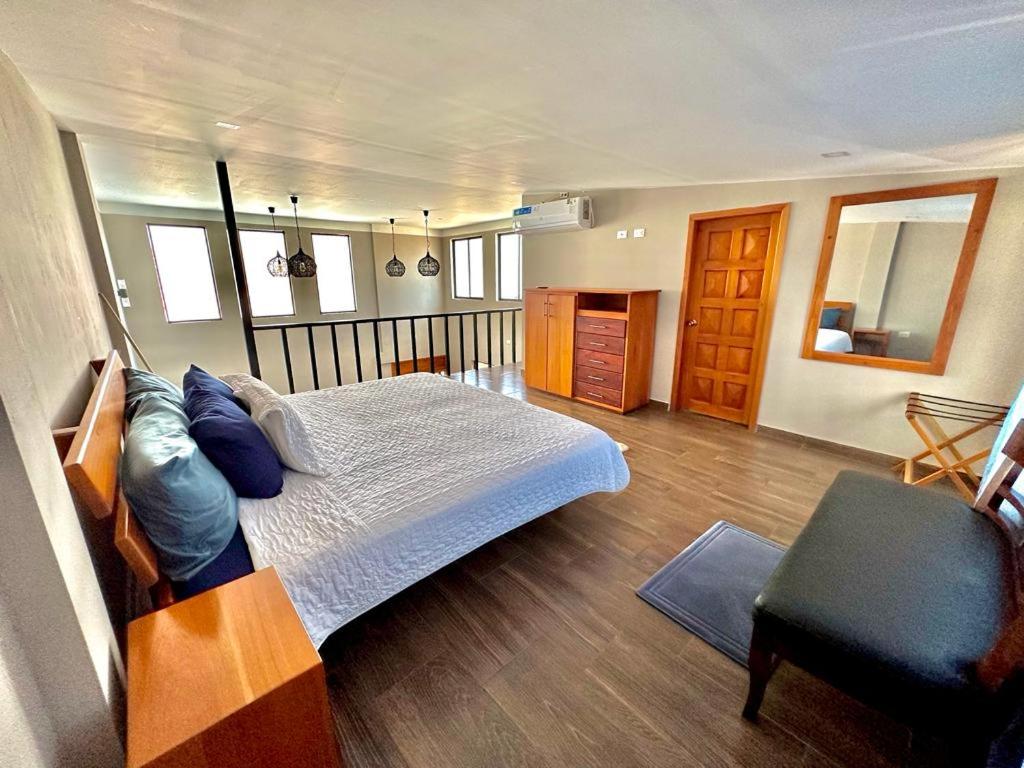 阿约拉港Suites Hermosas cercanas a todo的一间卧室配有一张床和一把椅子