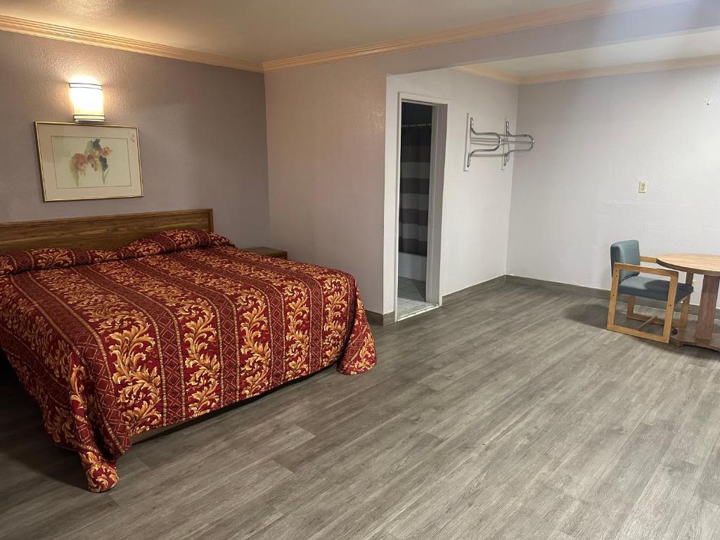 罗斯米德Plaza Inn Motel - Los Angeles area的酒店客房配有一张床铺和一张桌子。