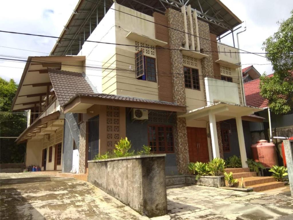 SintangWismaALAS Syariah Guesthouse的街道中央的房子