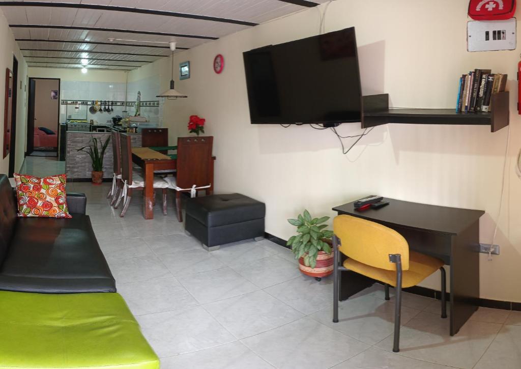 波帕扬Acogedor Apartamento en Centro de Popayán的客厅配有书桌和墙上的电视。