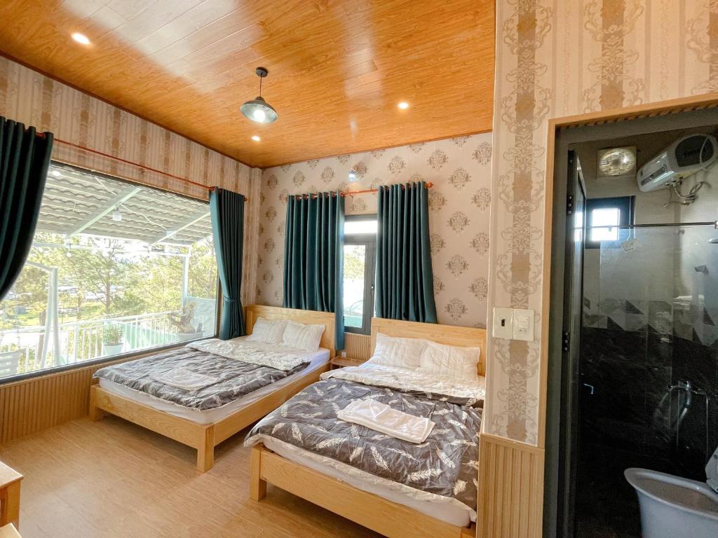 大叻Cẩm Tú Villa Đà Lạt的一间卧室设有两张床和窗户。