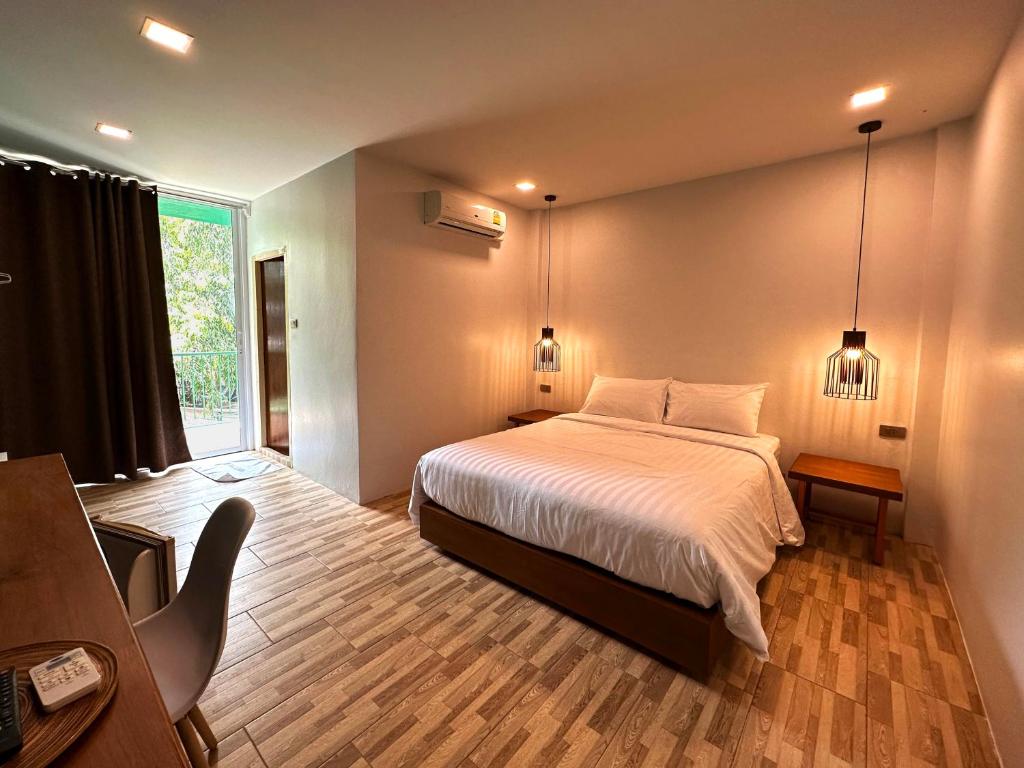素叻普乐佩琪酒店的一间卧室设有一张床和一个大窗户