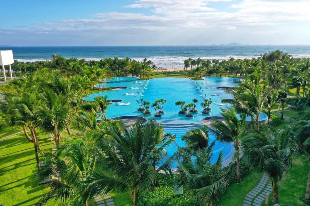 金兰市Seaview Arena Cam Ranh Nha Trang hotel near the airport的棕榈树度假村泳池的空中景致