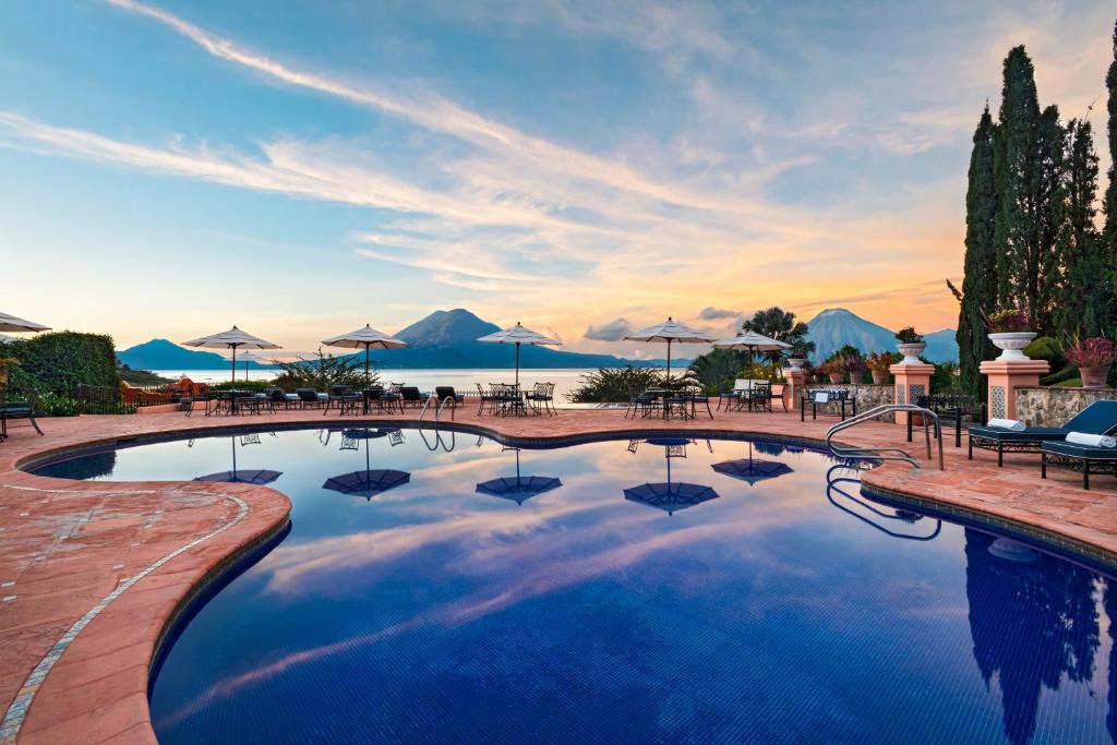 帕纳哈切尔阿迪特兰酒店的一个带遮阳伞和日落的大型游泳池