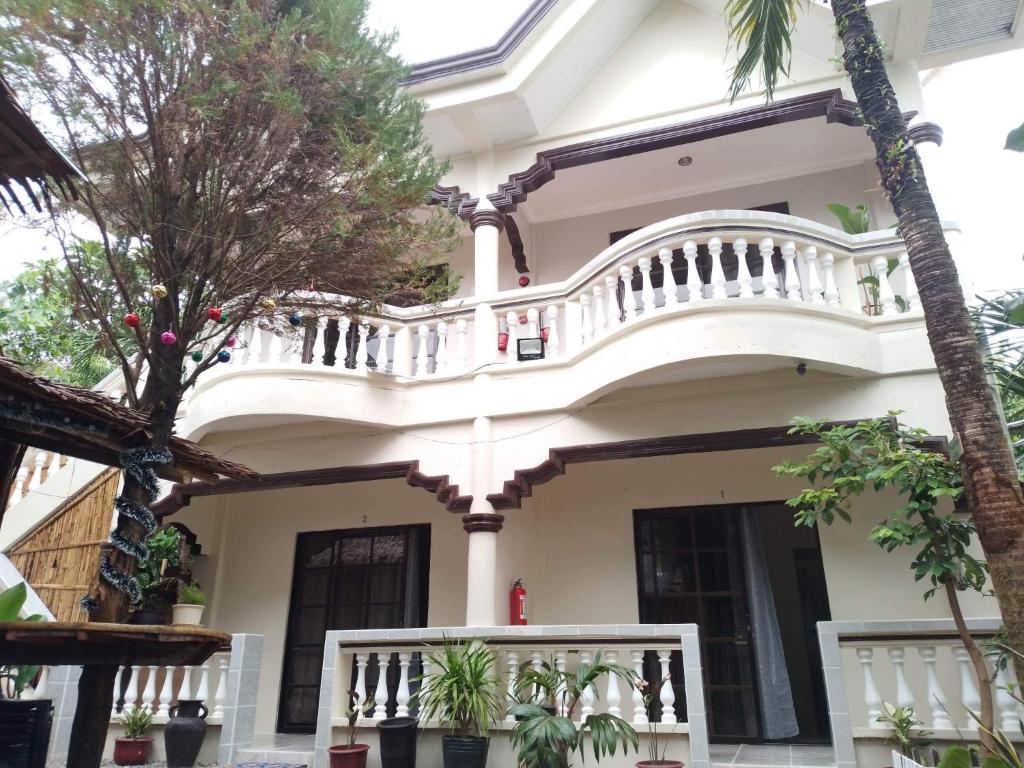 长滩岛Tresha Lance Apartelle的带阳台和棕榈树的白色房屋