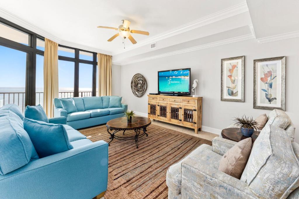 奥兰治比奇The Oasis at Orange Beach 2203的客厅配有蓝色的家具和平面电视。