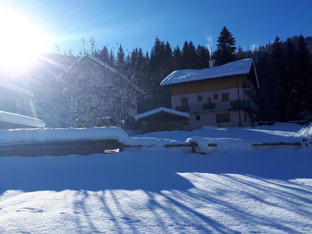 魏森湖米特雷尔旅馆的雪中的房子,太阳在后面