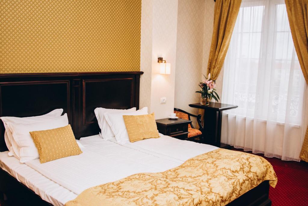 蒂米什瓦拉Hotel Novera的一间卧室配有一张带白色床单的床和一扇窗户。
