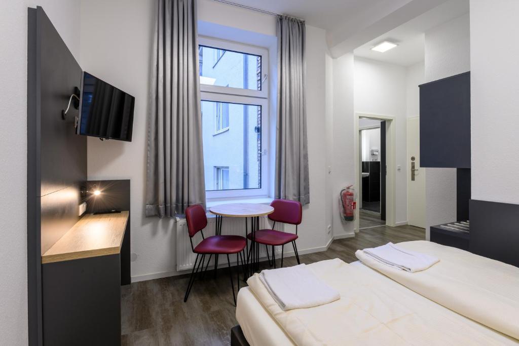 科隆Royale Apartaments Central City Cologne的酒店客房带一张床、一张桌子和椅子