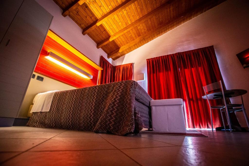 阿尔巴AlbaVillage Hotel & Camping Wellness的带沙发和红色窗帘的客厅