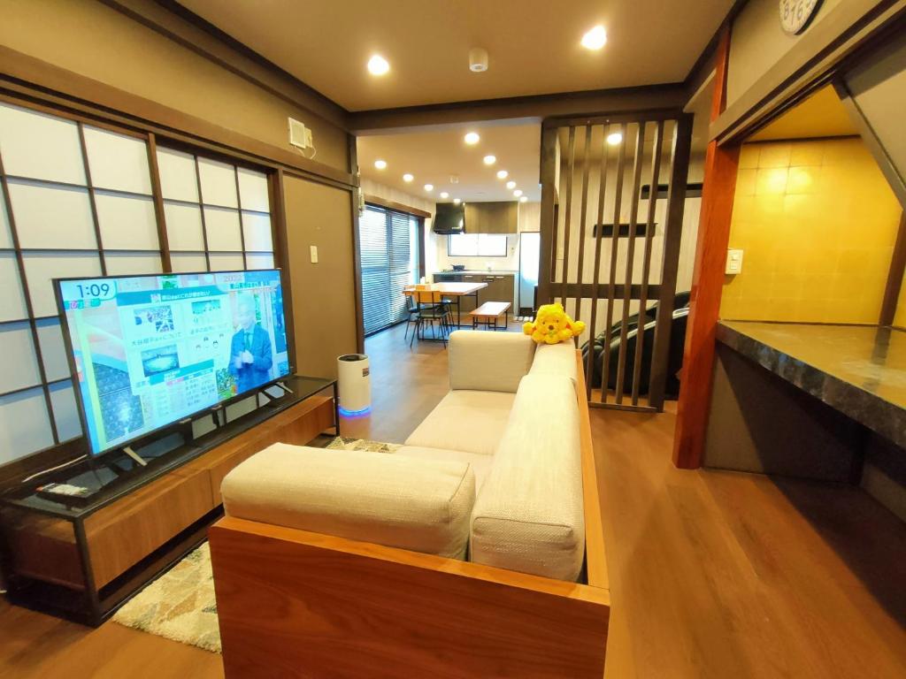东京KIKI HOUSE的带沙发和大屏幕电视的客厅