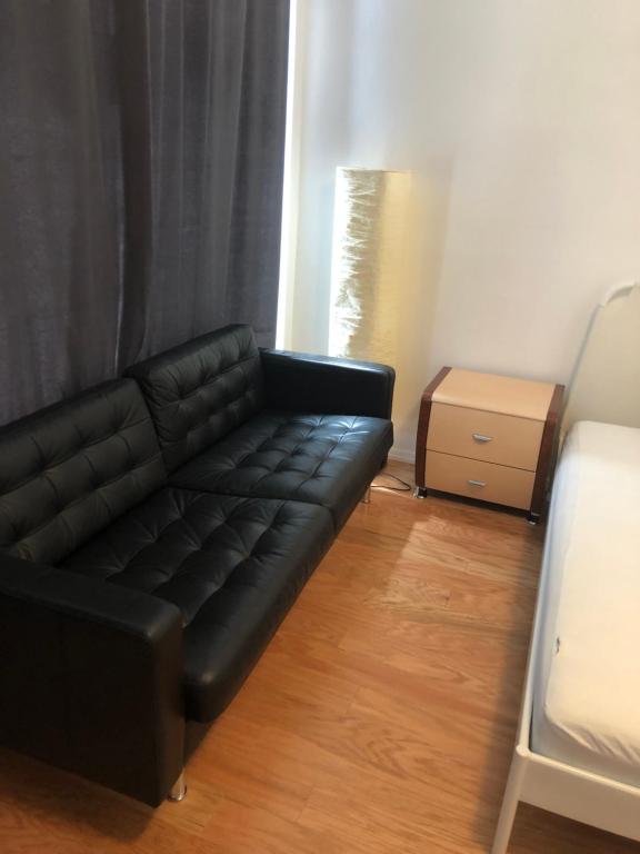 布鲁克林Beachside Brooklyn的客厅里一张黑色皮沙发