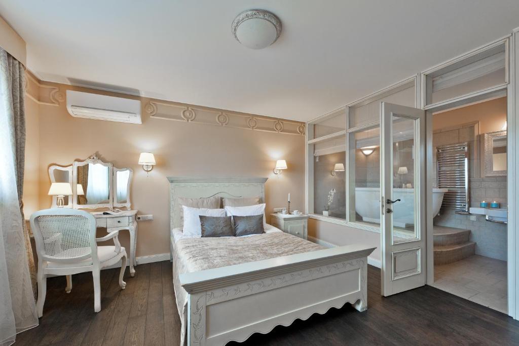 特拉凯维瓦塔卡尔酒店的一间卧室配有一张床、一张书桌和一面镜子