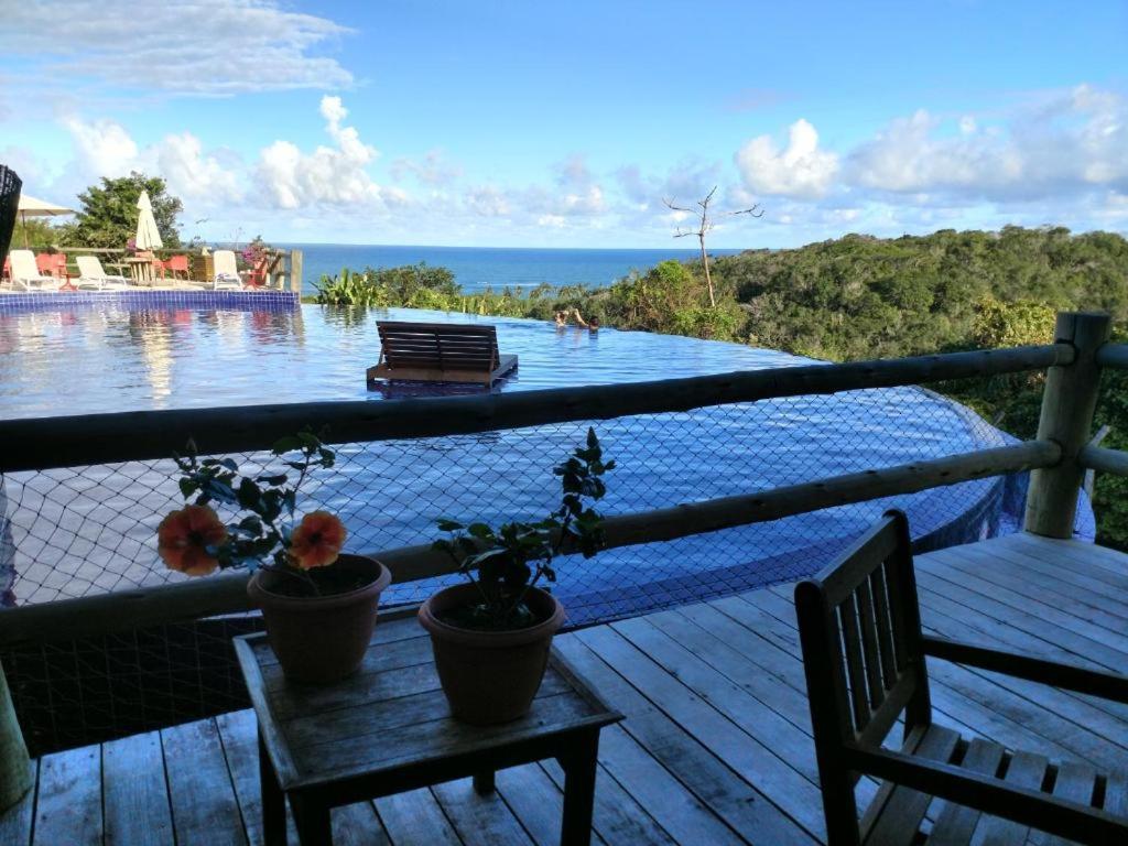 马塞约Villas do Pratagy resort Maceió próximo praia的从房子的甲板上可欣赏到游泳池的景色