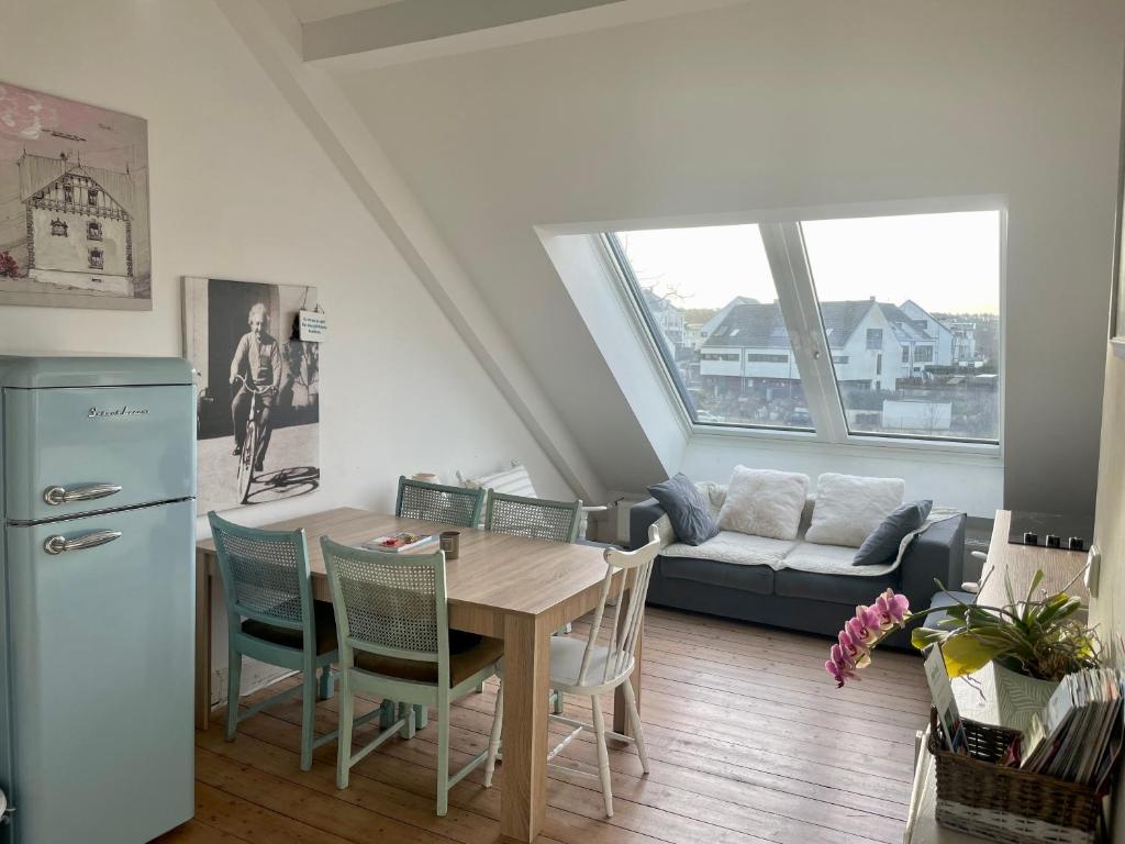 哈廷根Beautiful apartment in a historic villa的厨房以及带桌椅的起居室。