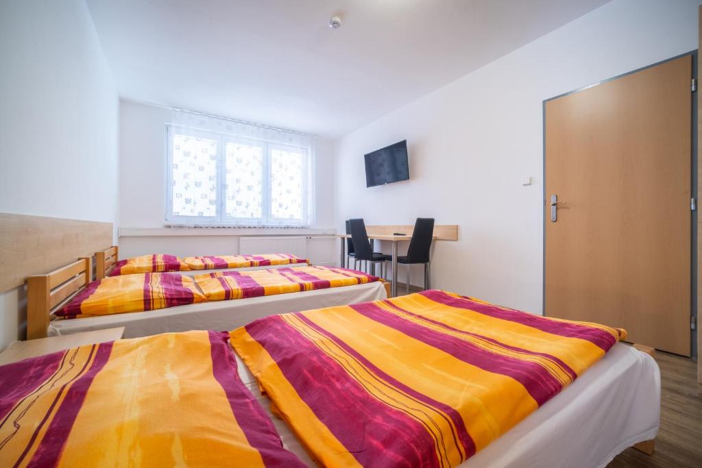 捷克布杰约维采Hotel U Nádraží的配有2张床的带窗户和桌子的客房