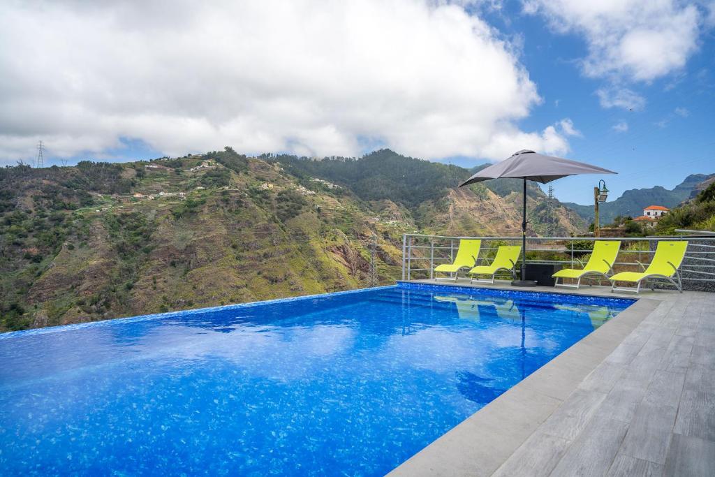 里韦拉布拉瓦Gran Horizonte House with private pool by HR Madeira的一个带椅子和遮阳伞的游泳池