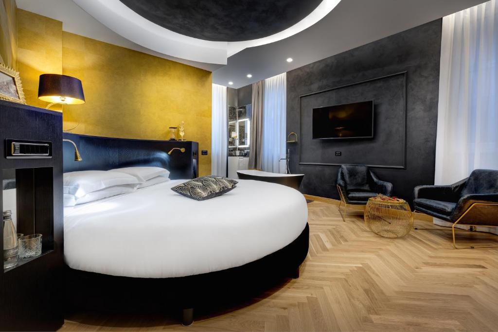 罗马Dharma Boutique Hotel & SPA的一间带白色大床的卧室和一间客厅
