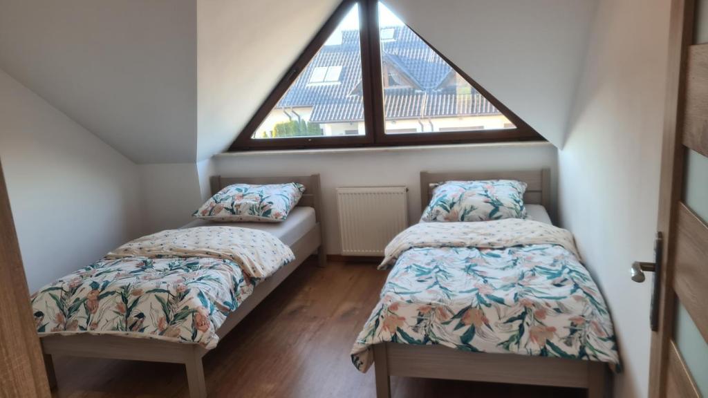 DomasławDom pod Wroclawiem16的阁楼卧室设有两张床和窗户。