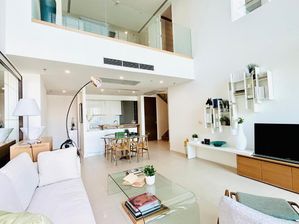 曼谷The river luxury two bedrooms的客厅配有白色沙发和玻璃桌