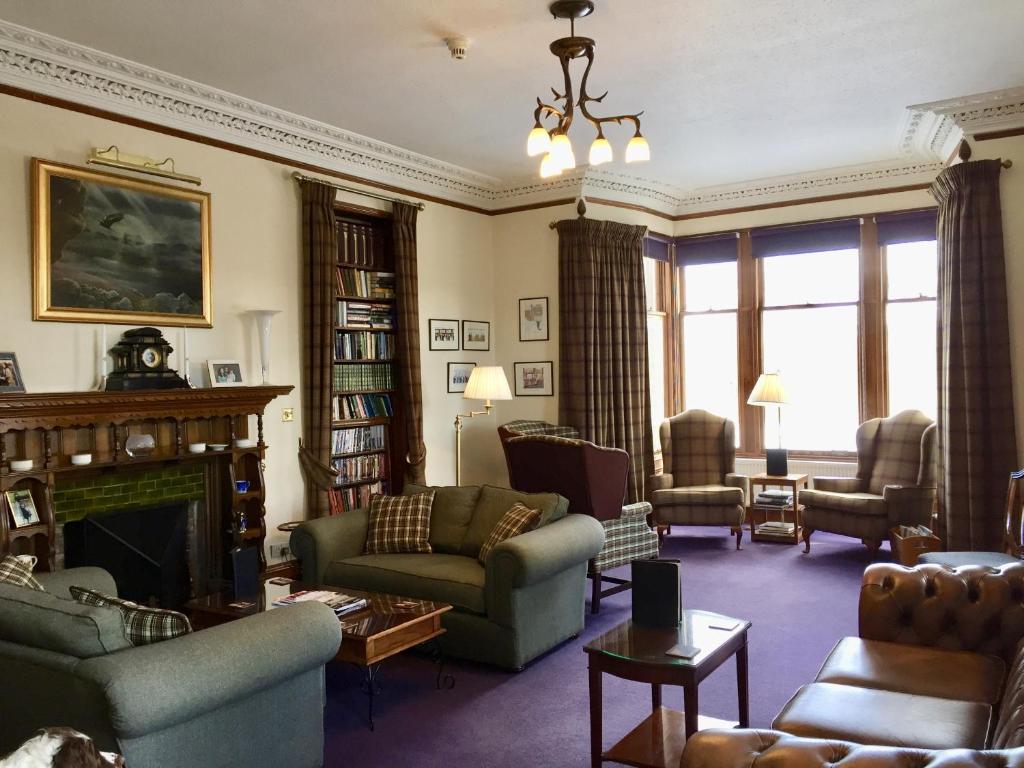 卡布里奇Dalrachney Lodge的客厅配有家具和壁炉