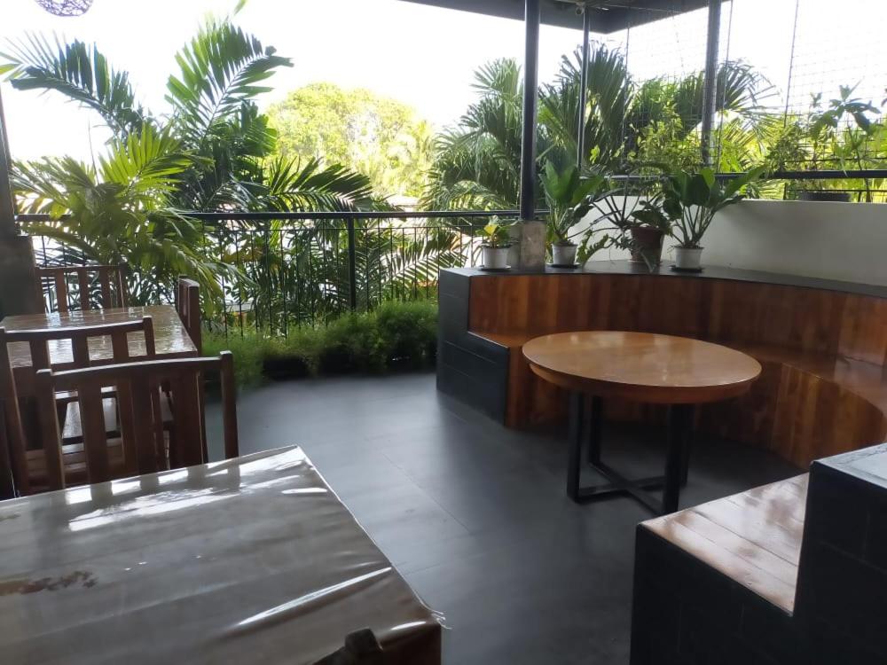 公主港Green Turtle Backpackers Guesthouse, Puerto Princesa的一个带桌椅和棕榈树的庭院