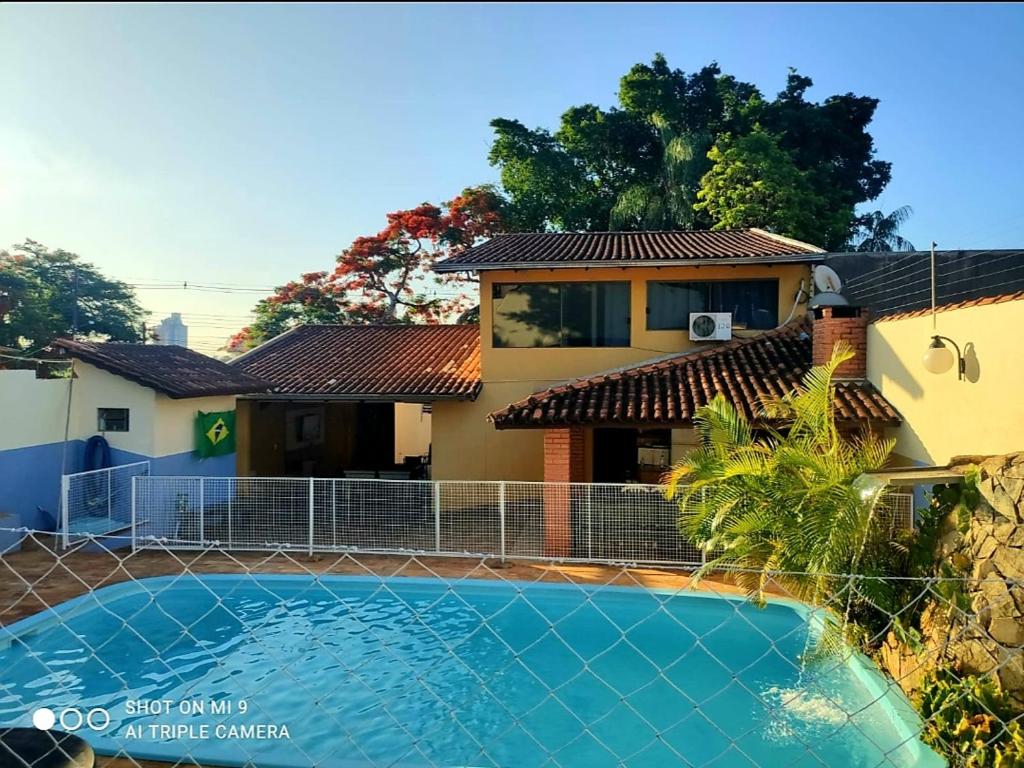 伊瓜苏Hostel Beija flor的一座房子前面设有游泳池