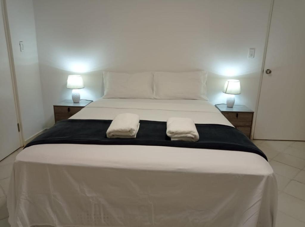 巴拿马城Doña Nancy的一张白色的大床,带两条毛巾
